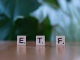 A wooden block spelling the word etf on a table