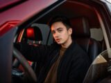 A man sitting in the driver's seat of a car