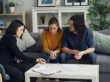 three women sitting on a couch talking to each other