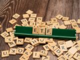 scrabble tiles spelling out letters on a wooden table