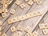 scrabble tiles spelling vacation on a wooden surface