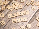 scrabble tiles spelling credit and risk on a wooden table