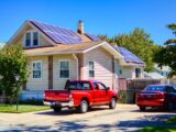 a red pick up truck parked in front of a house