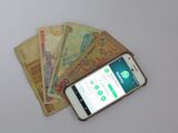 white Android smartphone beside banknotes