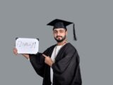 a person wearing a graduation cap and gown holding a sign