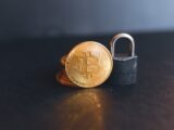 a bit coin sitting on top of a padlock