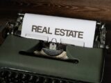 a close up of a typewriter with a real estate paper on it