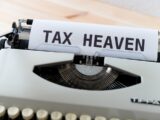 a close up of a typewriter with a tax heaven sign on it