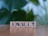 A wooden block spelling the word linux on a table