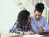 Mother and daughter studying together at a table.