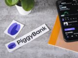 a cell phone sitting next to a piggy bank sticker