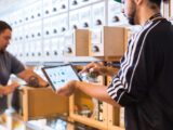 two men in a store looking at a tablet