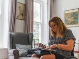 Woman sitting in a chair looking at papers.