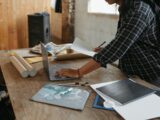 a woman sitting at a table working on a laptop