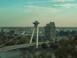 a bridge over a river with a city in the background