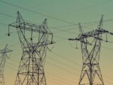 black transmission towers under green sky