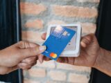 a person handing a credit card to another person
