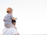 man in white shirt carrying boy