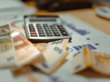 A calculator sitting on top of a pile of money