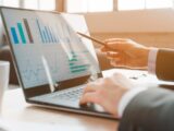 person analyzing business charts on laptop