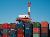 a crane is on top of a large stack of containers