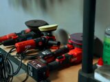 Several red car polishing tools on a shelf.