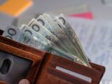 Brown leather wallet stuffed with polish currency.