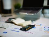office desk with smartphone and financial charts