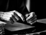a black and white photo of a person's hands on a book