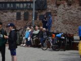 a group of people sitting on a bench next to a brick building