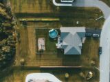 Drone shot of a house and garden with a swimming pool and play area.