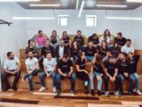 a group of people sitting on top of a wooden bench