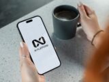 Person holding smartphone with ai platform logo.