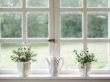 white teapot and tow flower vases on windowpane
