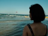 Woman looking at parasailer over the ocean