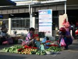 A woman sells vegetables at an outdoor market