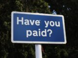a blue sign that says have you paid?